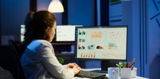 Mujer sentada frente al computador analizando gráficas para mejorar su negocio